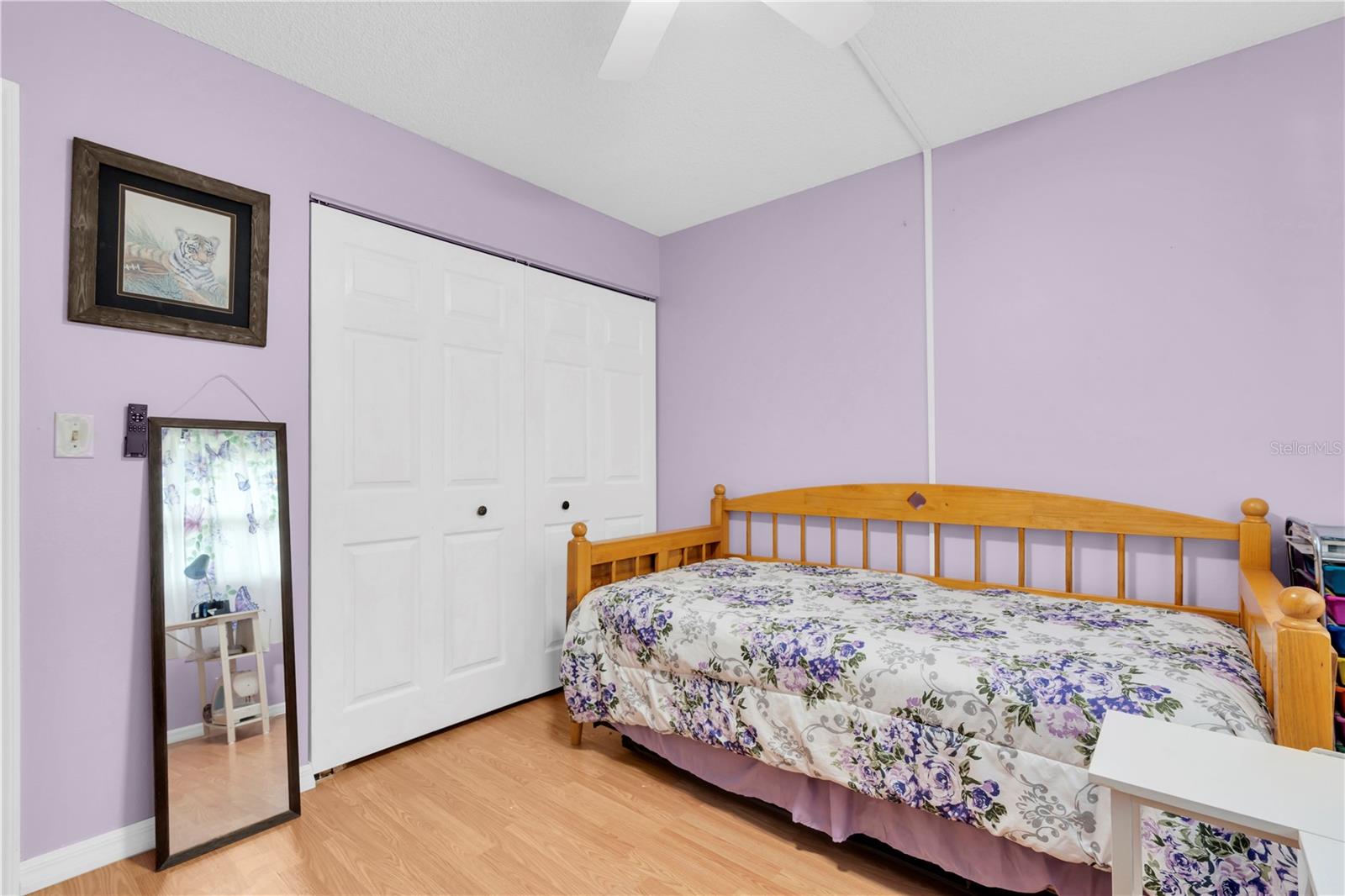 Second bedroom with natural light, ceiling fan, and closet