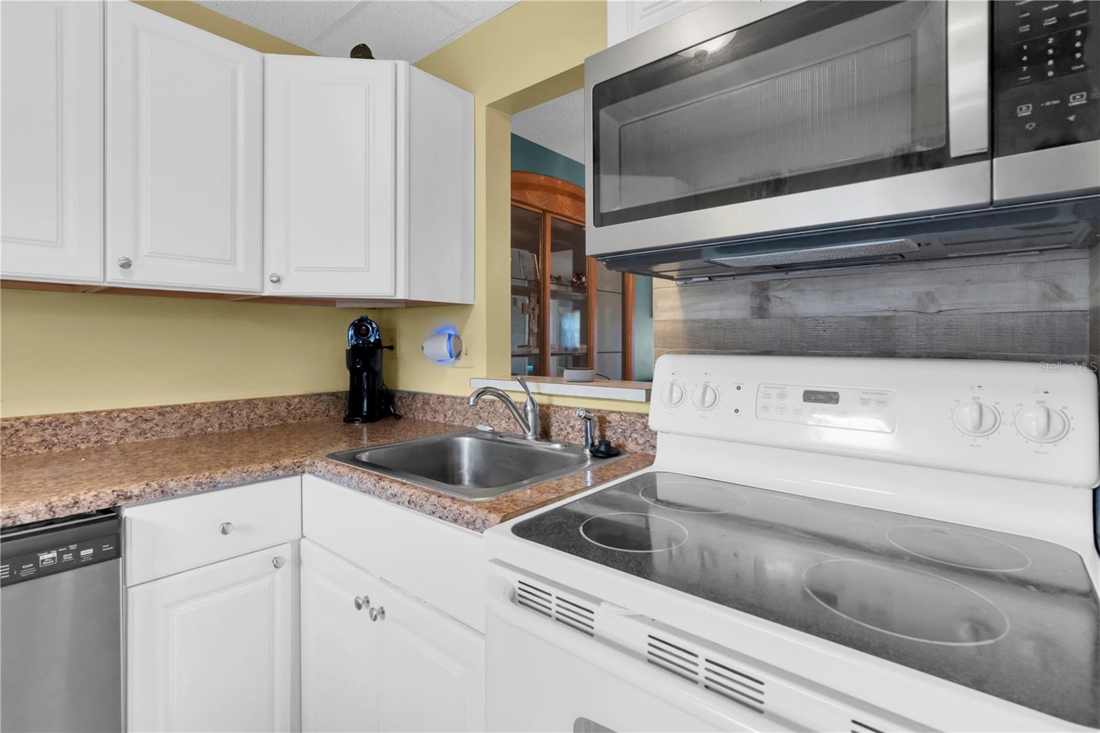 Kitchen with microwave over range and pass through to dining area