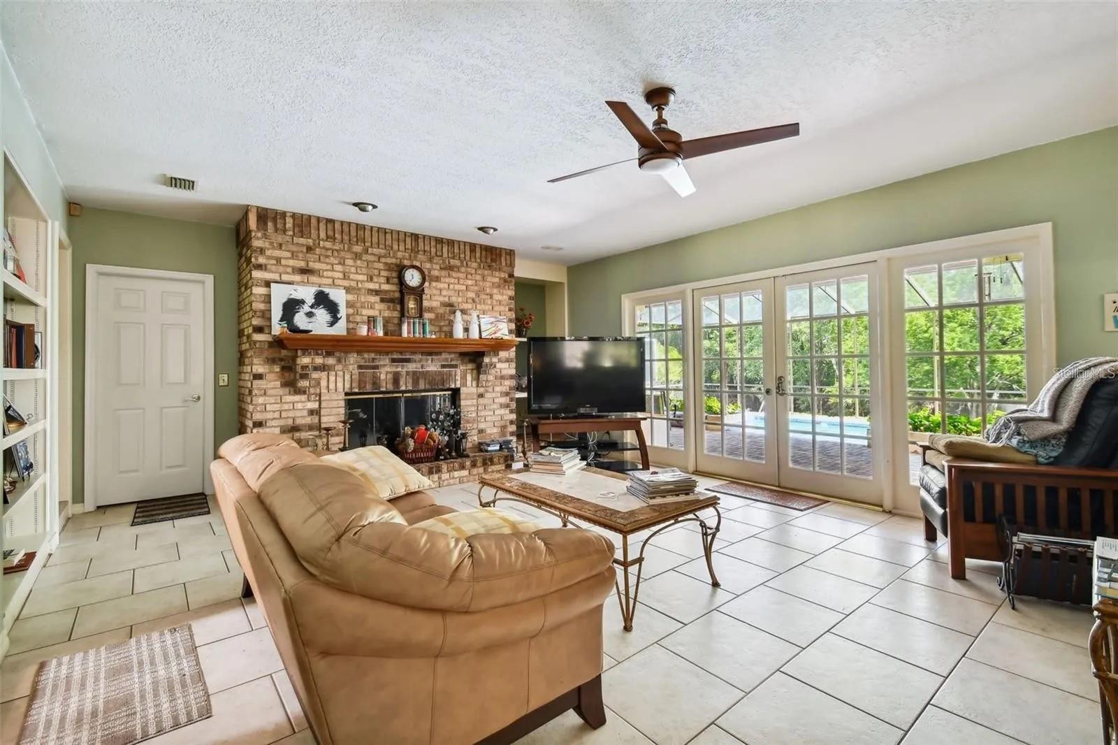 Family room is open to the kitchen and French doors leading to the pool