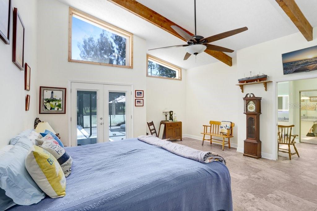 Oversized Primary Bedroom with French doors leading out to the Pool patio and Vaulted Ceilings