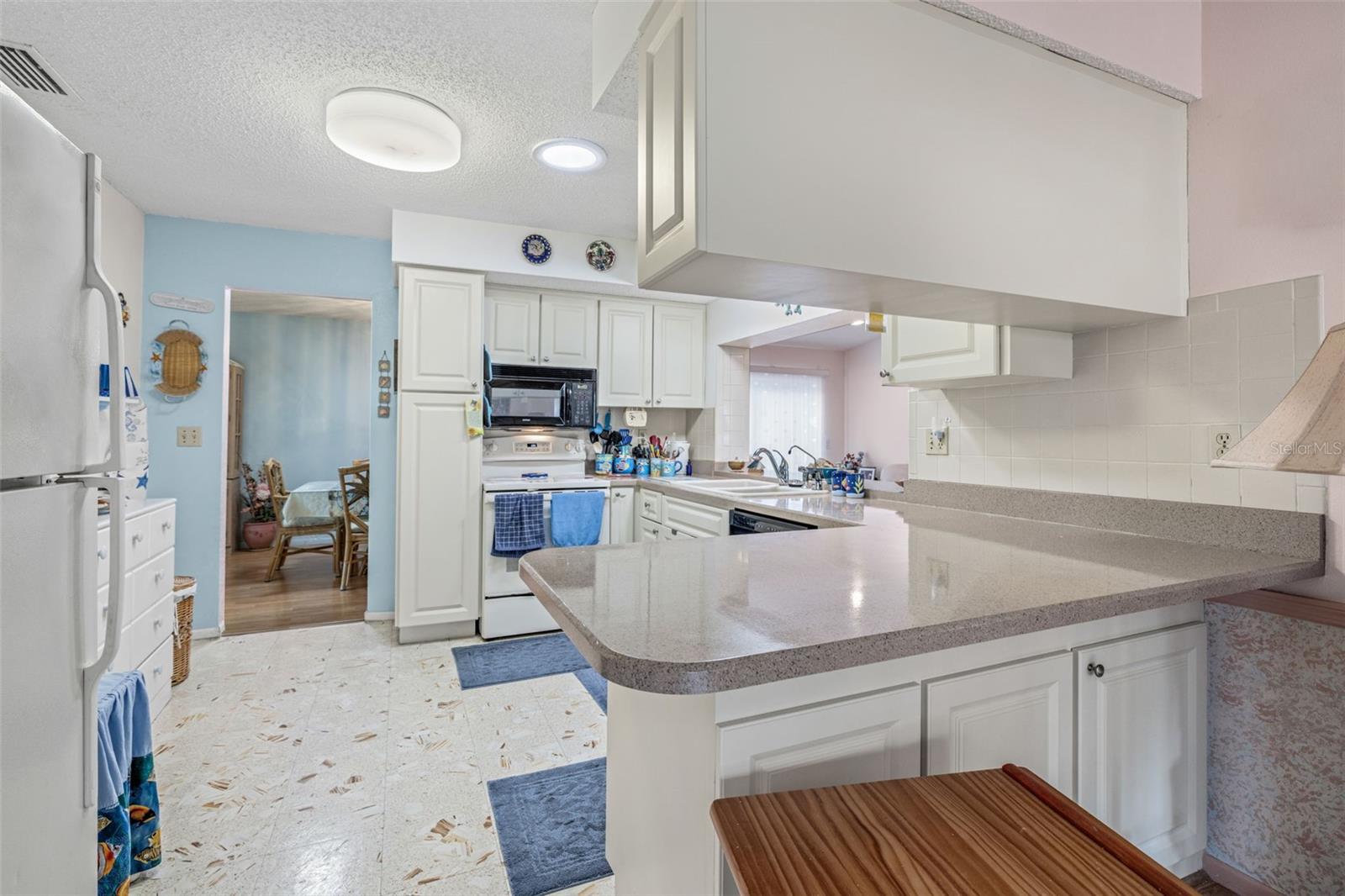 The kitchen provides ample storage and countertop space as well as ease of entertaining to the dining room.