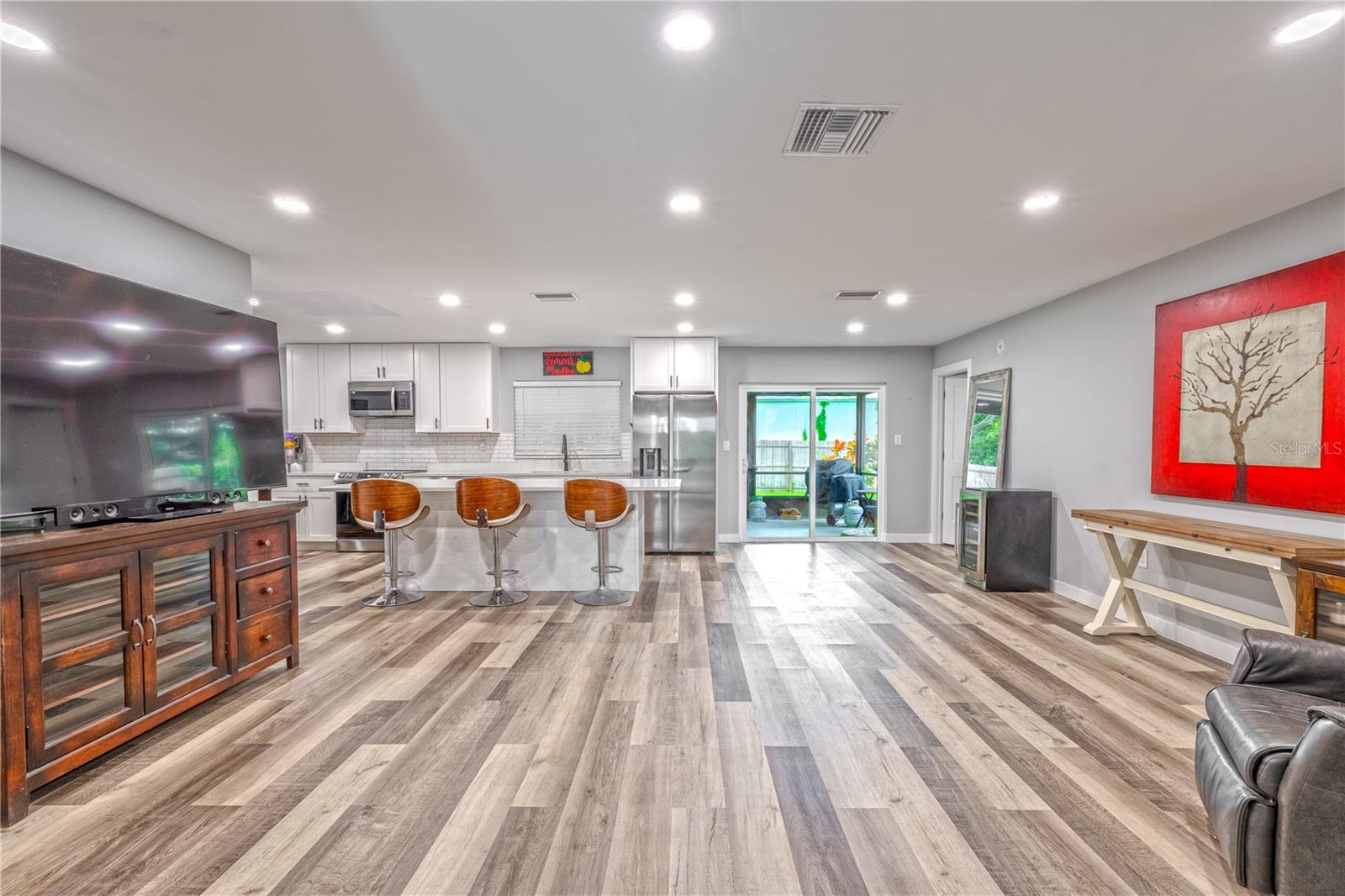 Open-concept living area with vinyl plank flooring and recessed lighting.