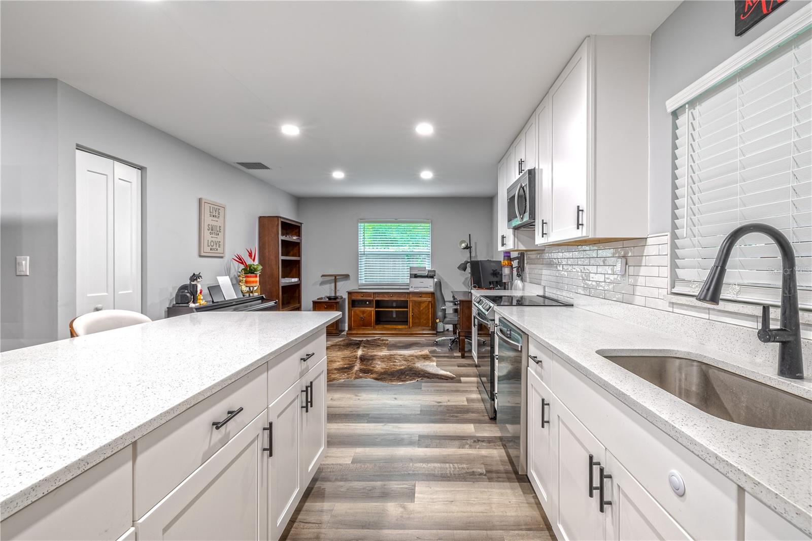 Kitchen workspace with undermount stainless steel sink, pull-down faucet, and subway tile backsplash.