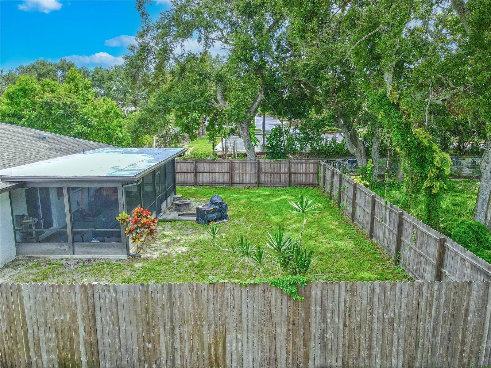 The screened-in porch offers a shaded retreat overlooking the backyard, perfect for relaxing or entertaining.