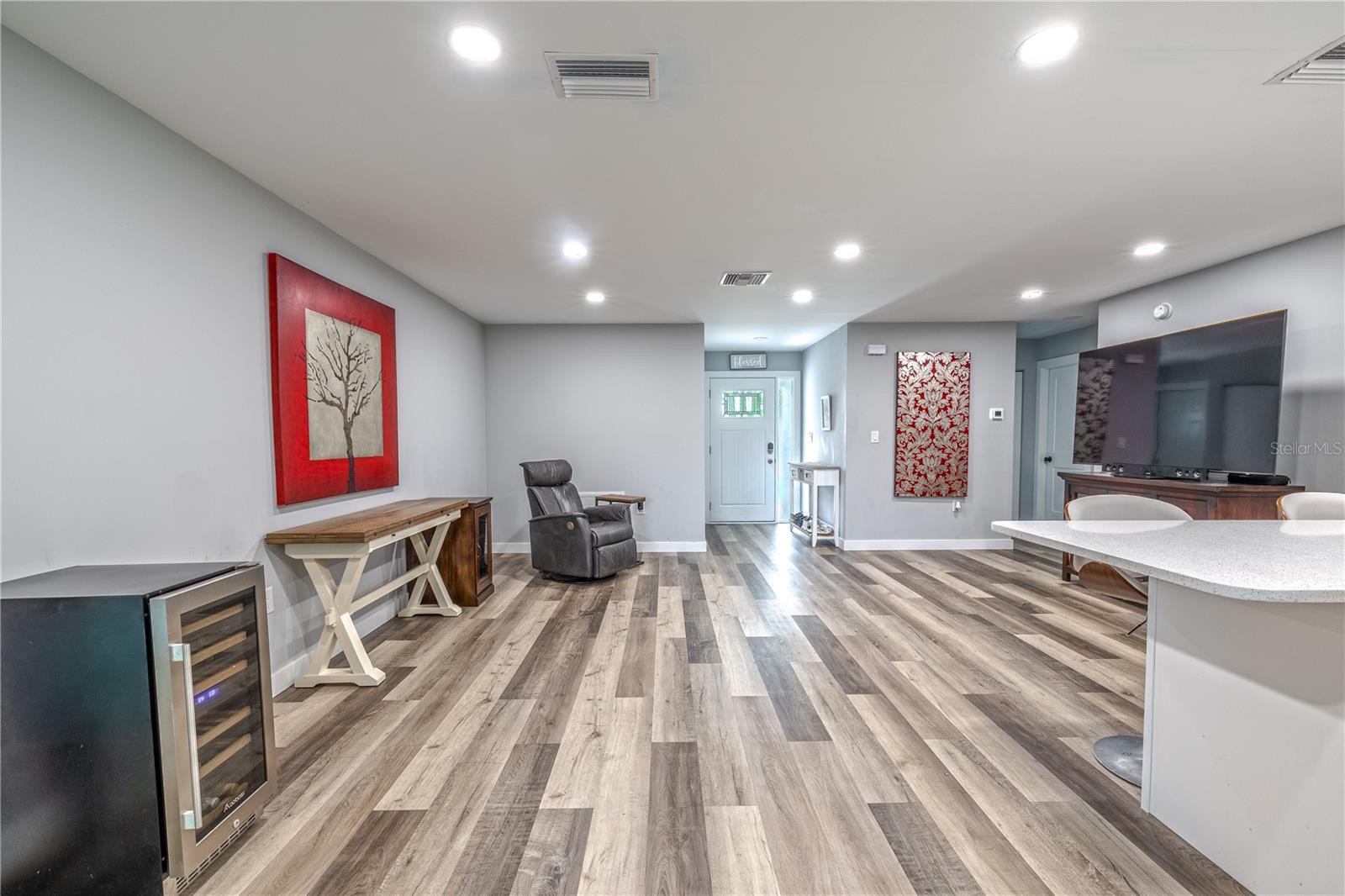 Living room with ample wall space for art or media, open to the kitchen.