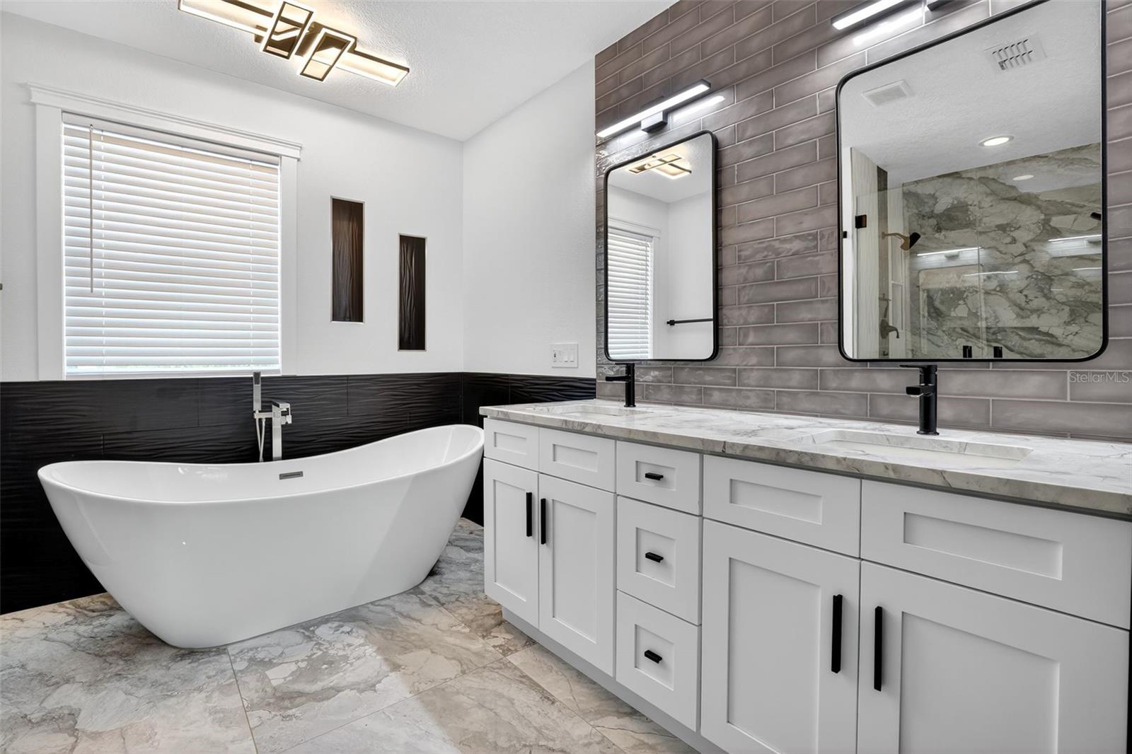 Designer-inspired primary bathroom with separate soaking tub.