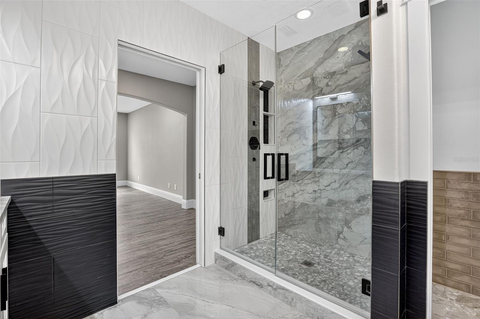 Large format tiles continue into the back shower wall for a seamless look.