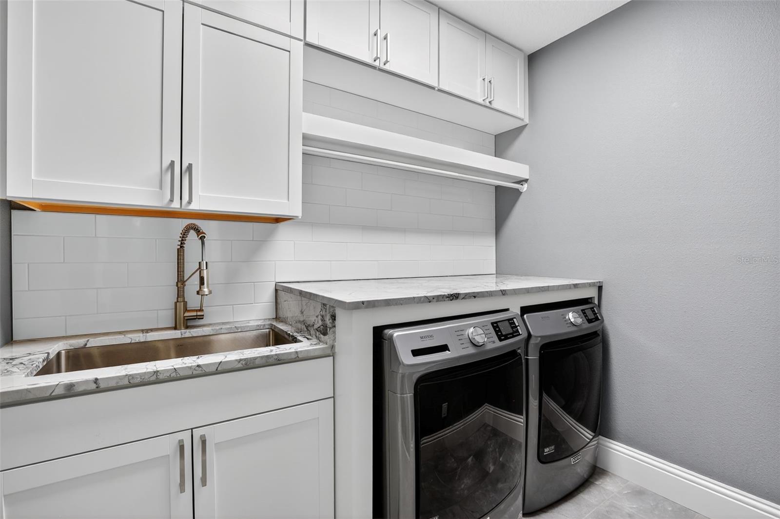 Custom built-in cabinets with updated countertops & floating shelf with clothes hanging rod for added convenience.