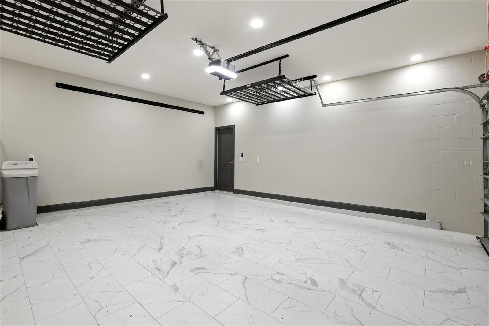 Garage also features marble-look tile flooring for easy cleaning & water softener system.
