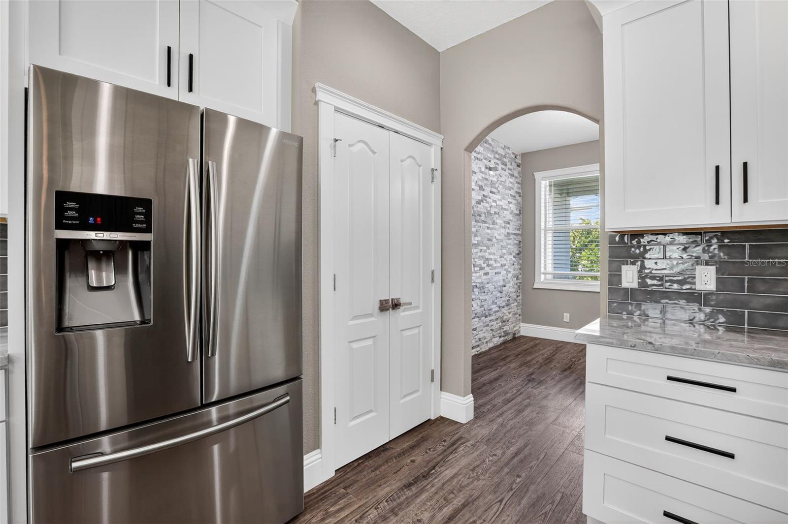 Kitchen Samsung Refrigerator coveys. Pantry closet with custom shelving to the right.