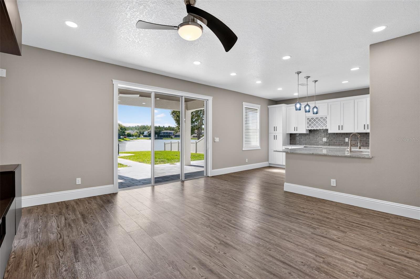 Large sliding glass doors provide a stunning back yard view to the pond.