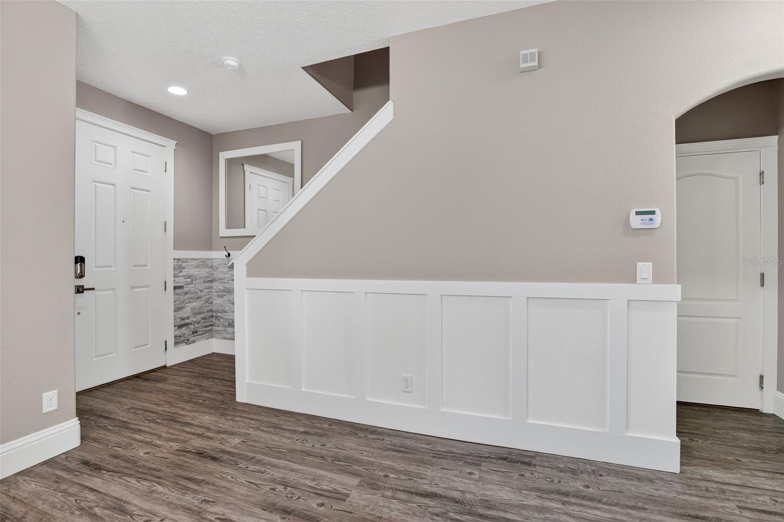 Front entry with stone & wood wainscotting details. Custom mirror included.