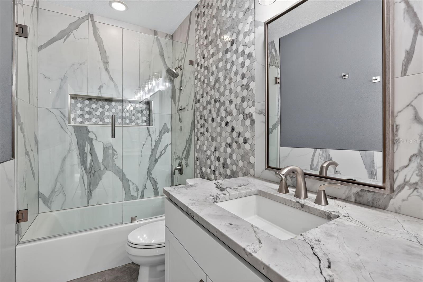 Jack & Jill bath with glass enclosure to showcase the gorgeous tile & niche.
