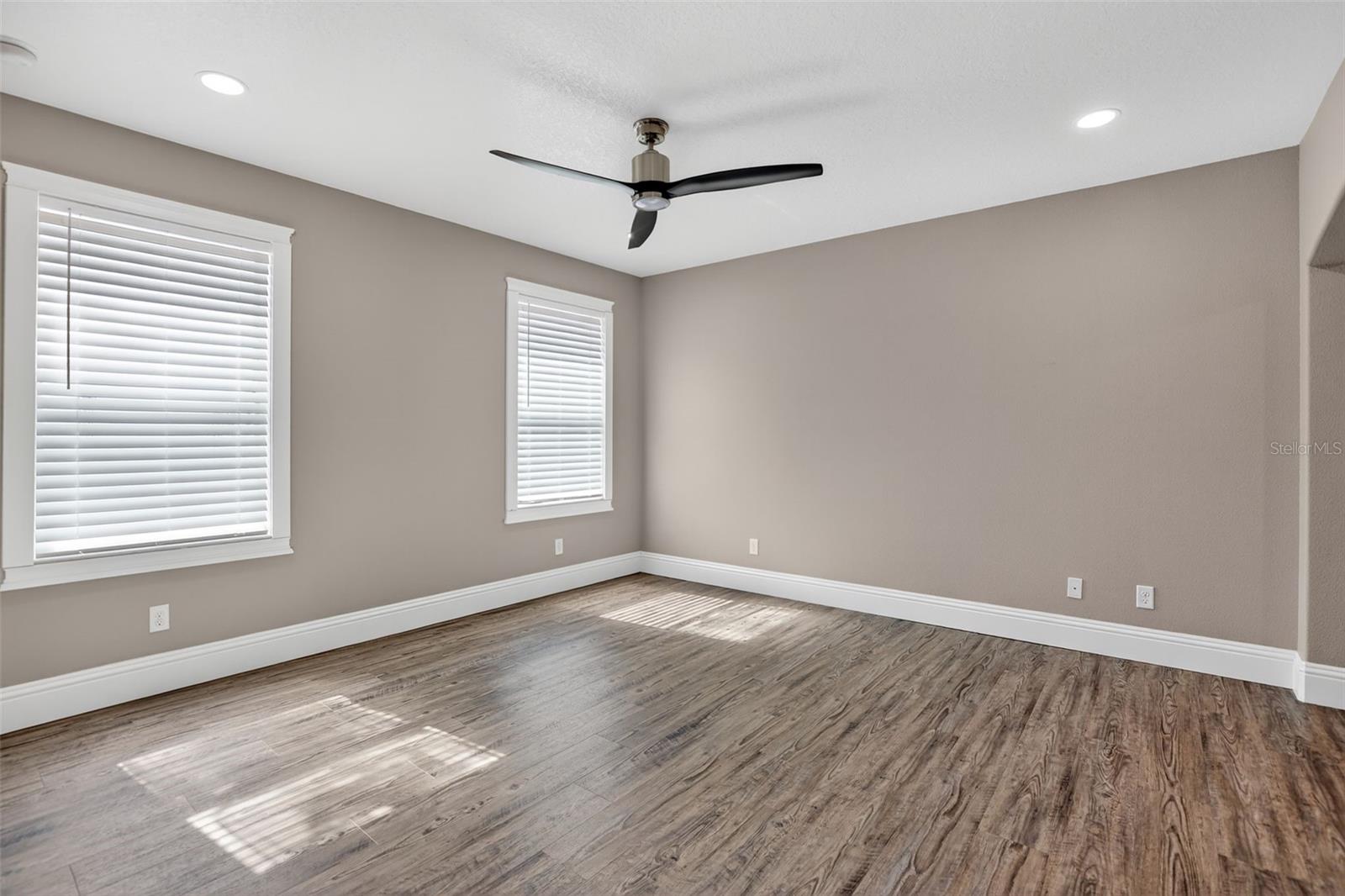 Primary bedroom has two large windows overlooking the backyard with lots of natural light.