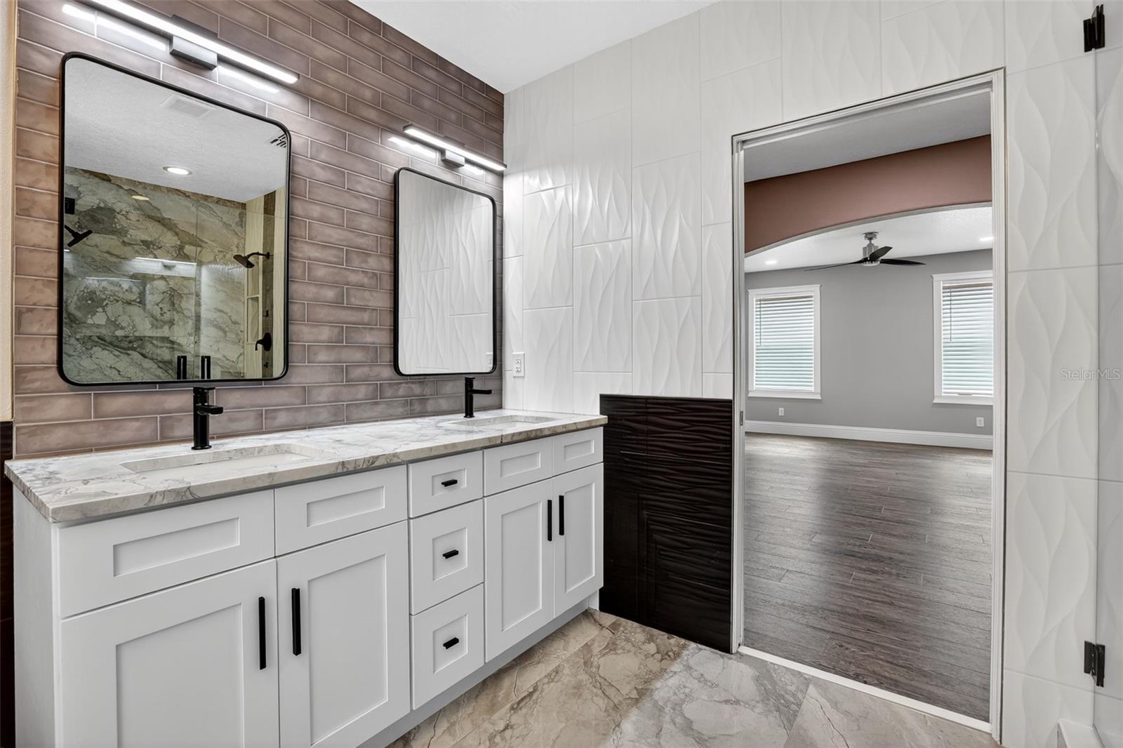 Primary bathroom vanity with neutral gray tile backsplash & modern color palette.