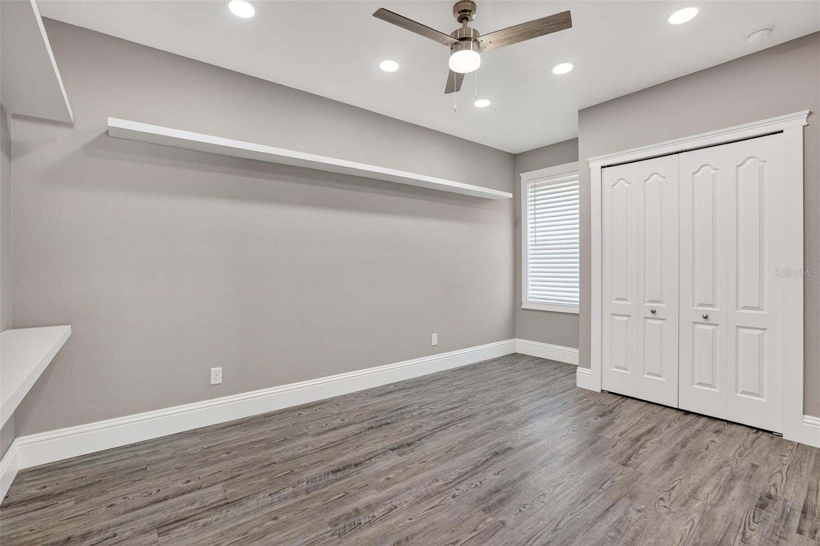 This guest bedroom has *8* flush mount canless LED lights. More custom shelving in the closet as well!