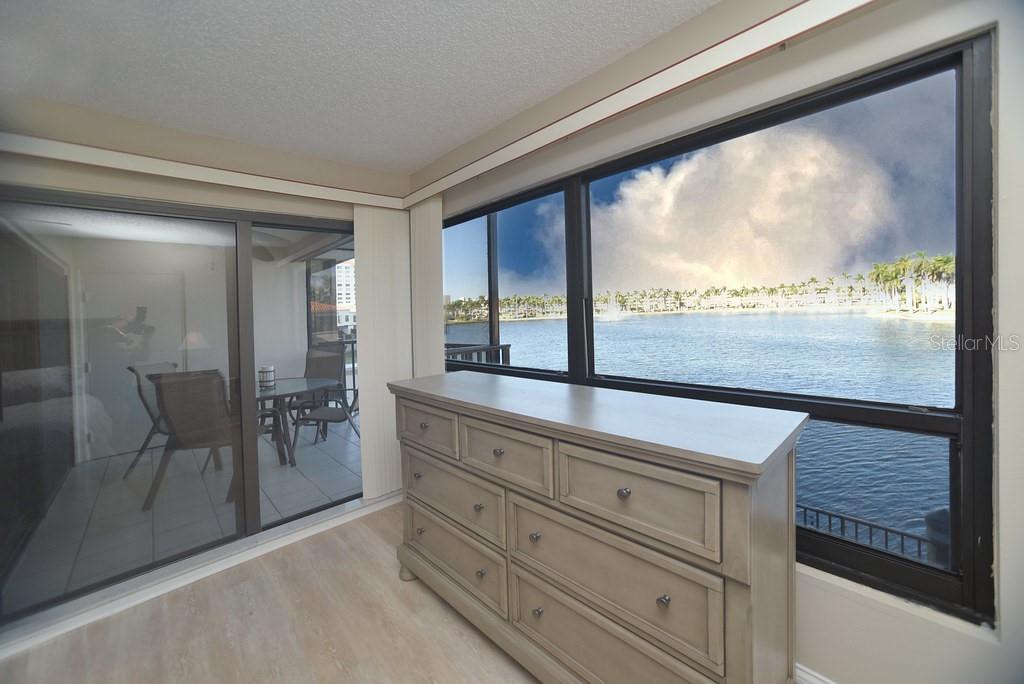 Primary bedroom with view to lake and patio