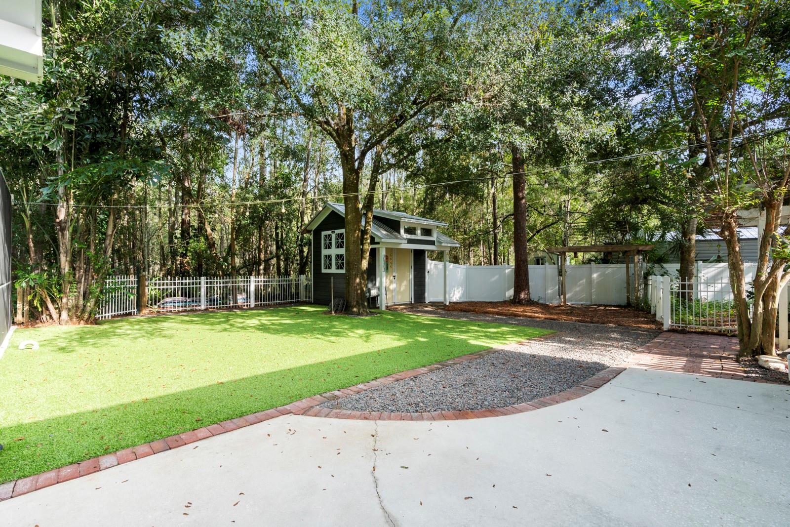 Fully fenced in yard with astro turf for pups and playground area
