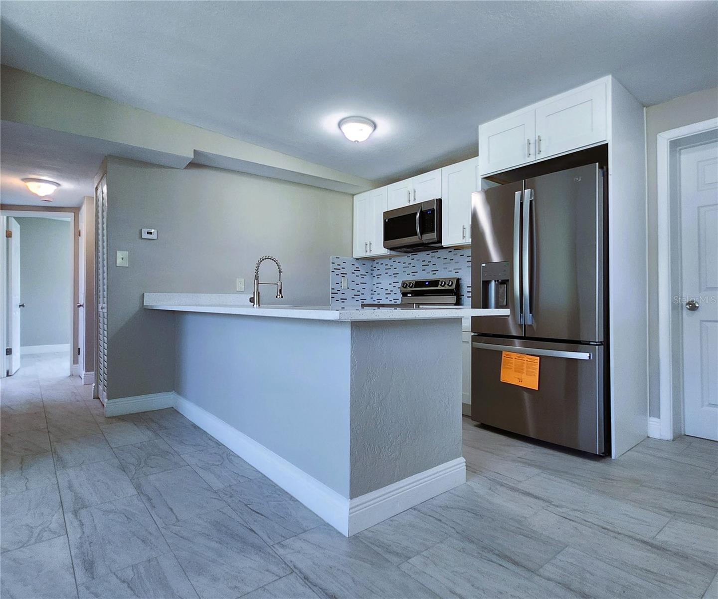 Kitchen includes granite countertops,  backsplash, new refrigerator, new stove, new microwave