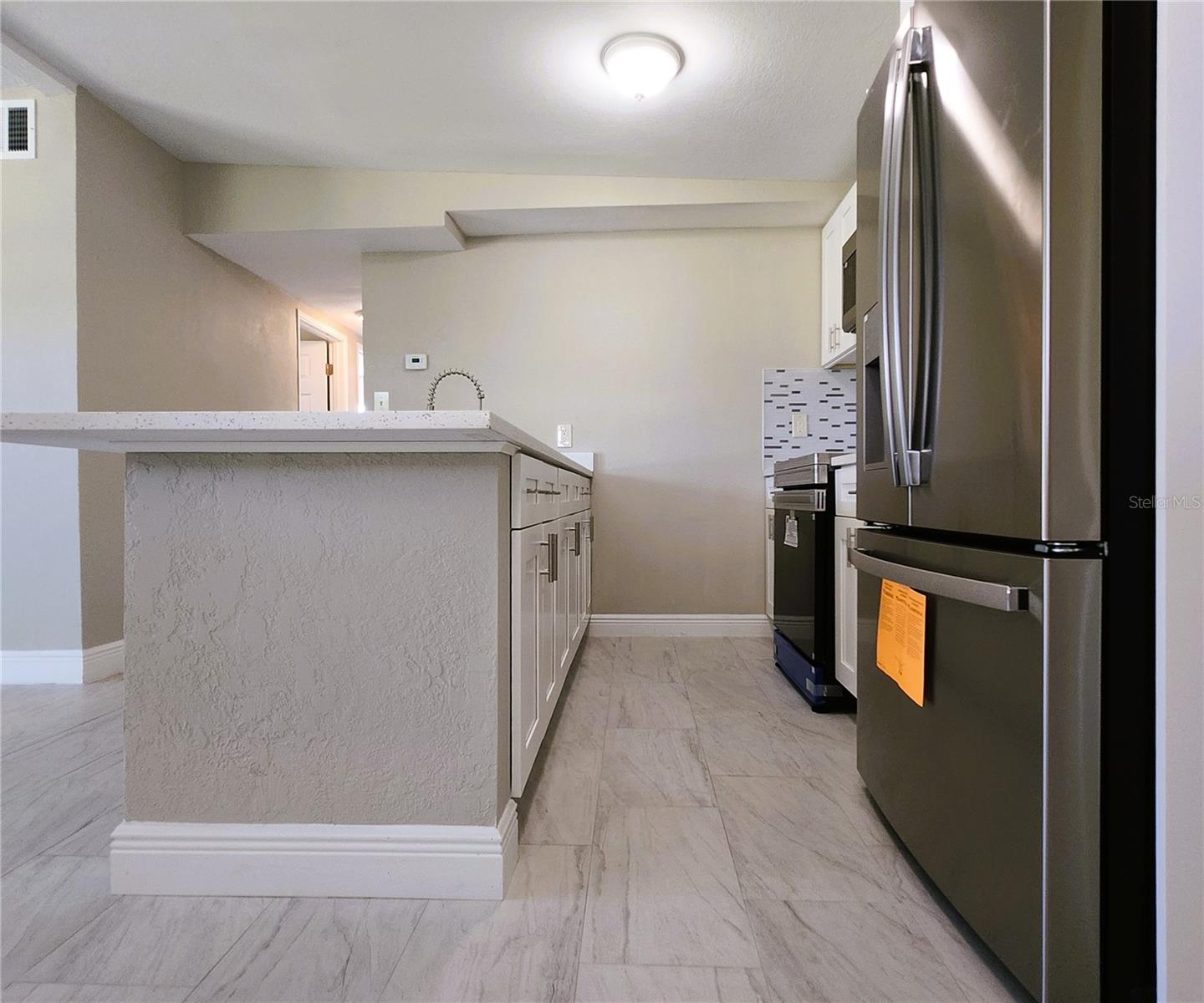 Kitchen includes granite countertops,  backsplash, new refrigerator, new stove, new microwave