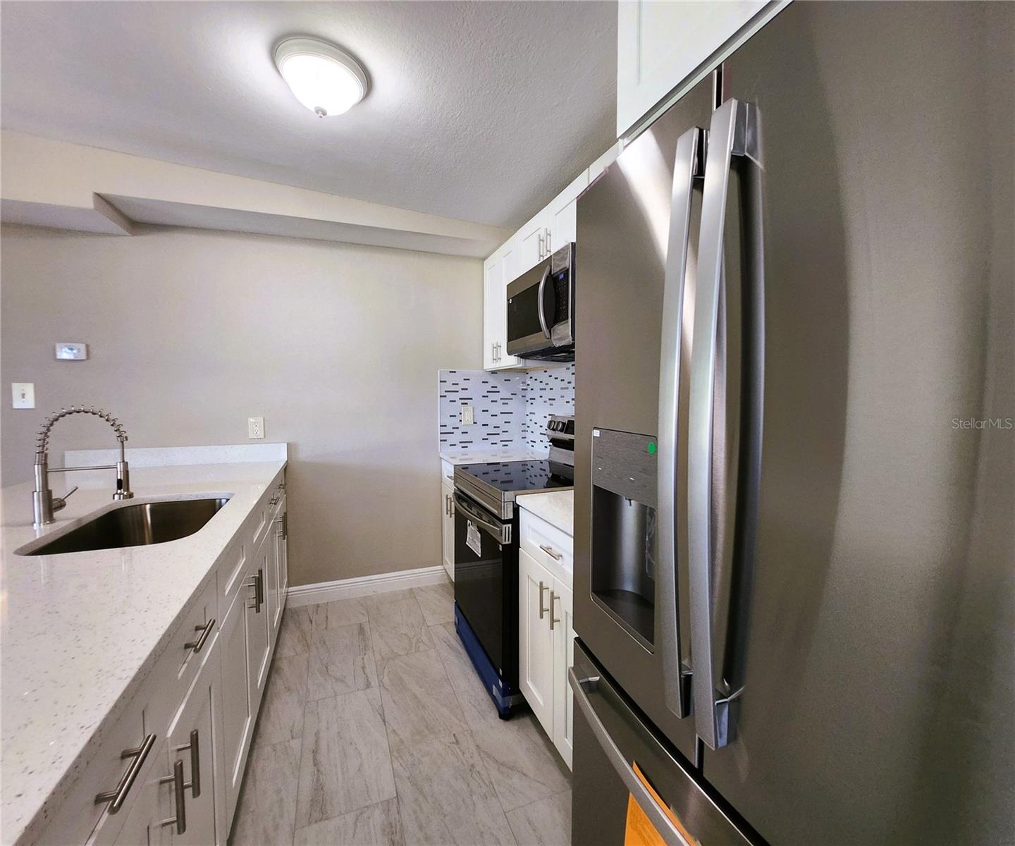 Kitchen includes granite countertops,  backsplash, new refrigerator, new stove, new microwave