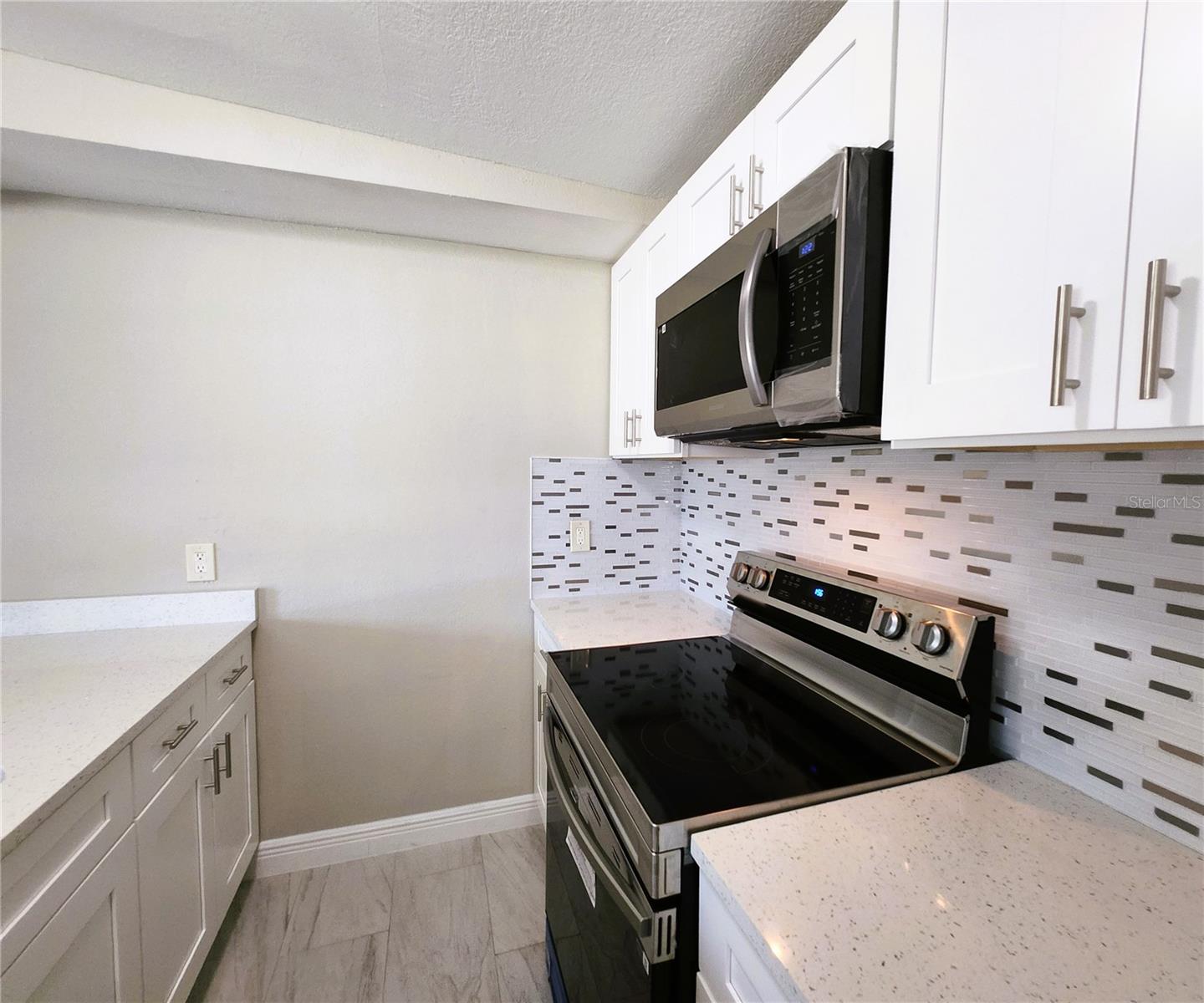 Kitchen includes granite countertops,  backsplash, new refrigerator, new stove, new microwave
