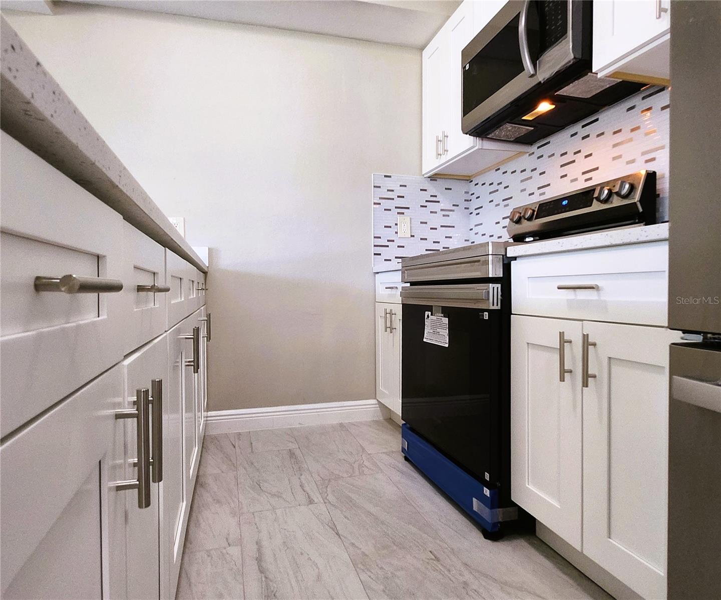Kitchen includes granite countertops,  backsplash, new refrigerator, new stove, new microwave
