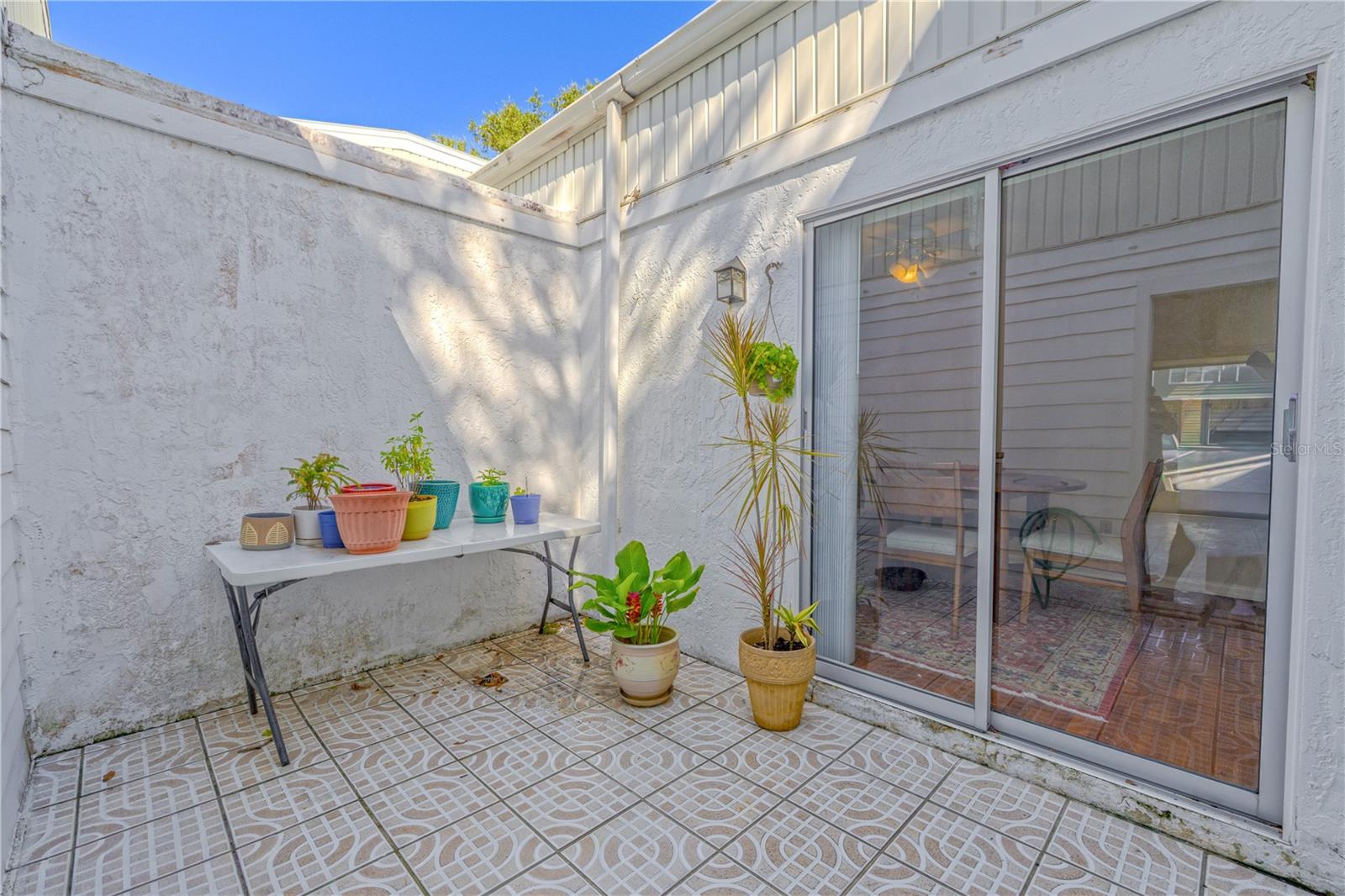 Private courtyard patio connects the living room, dining area, and garage for seamless indoor-outdoor living.