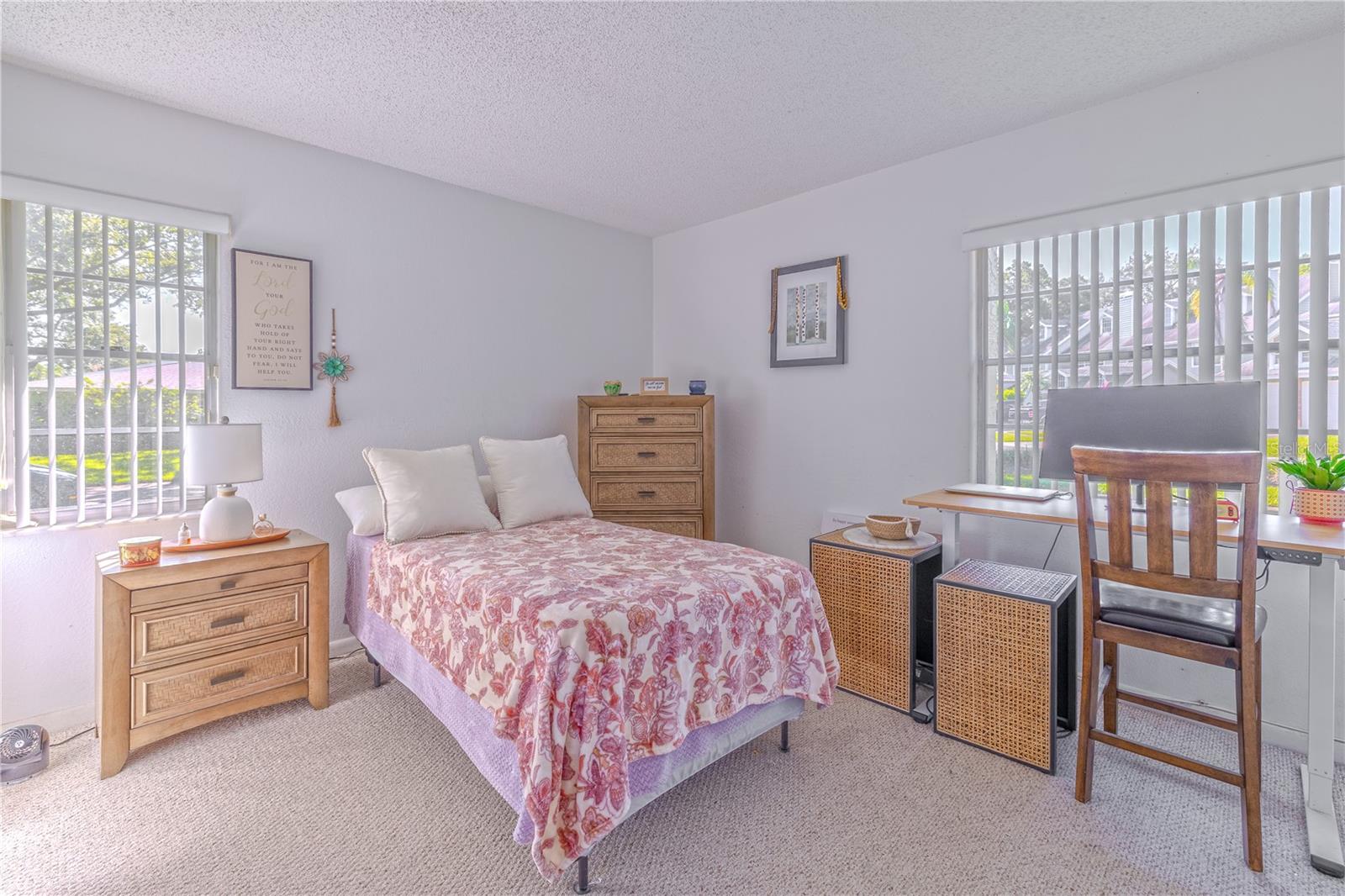 Bright second bedroom with dual closets and natural light, perfect for guests or a home office.
