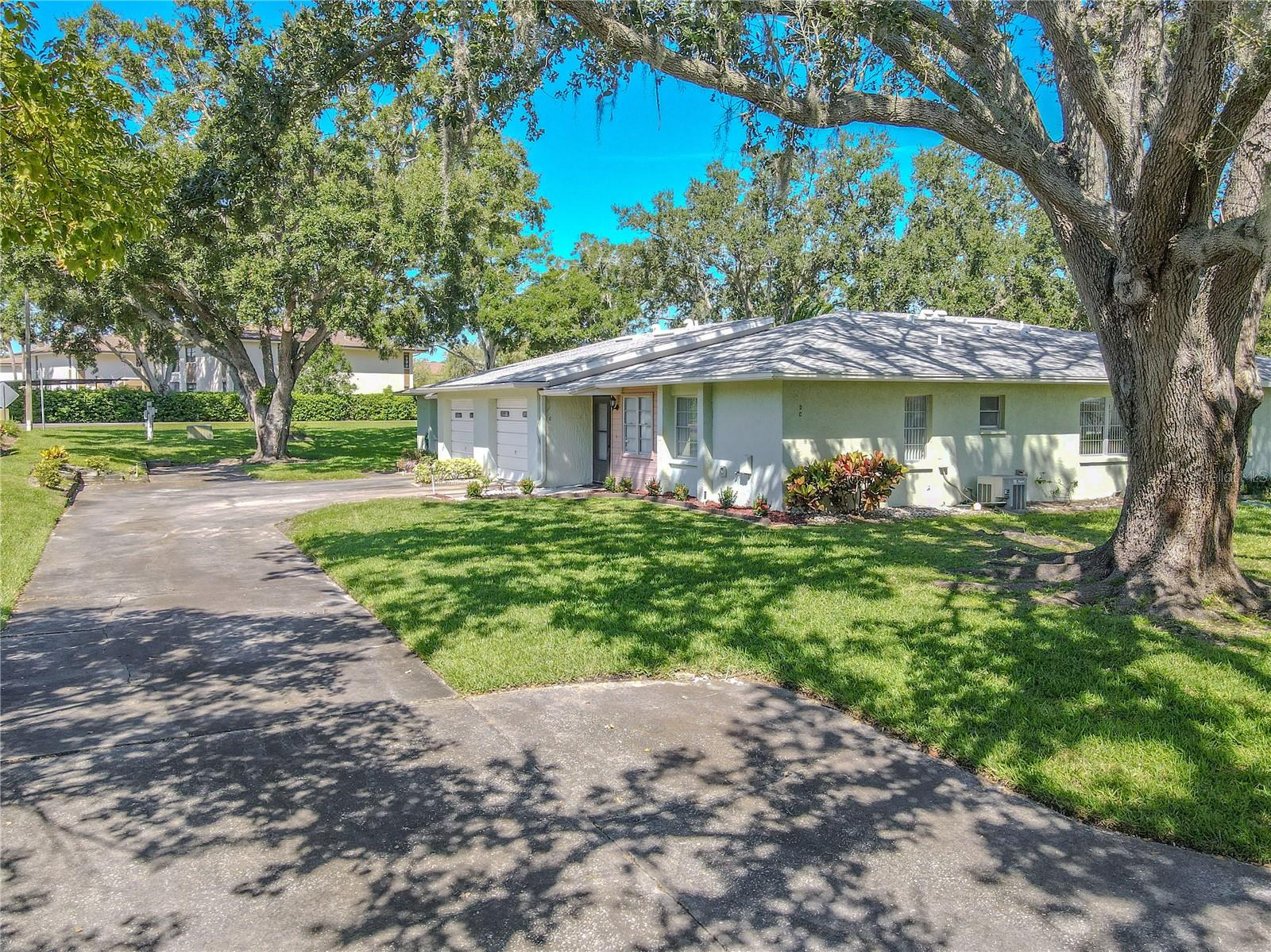 Shady oak trees surround the property, creating a peaceful neighborhood backdrop.