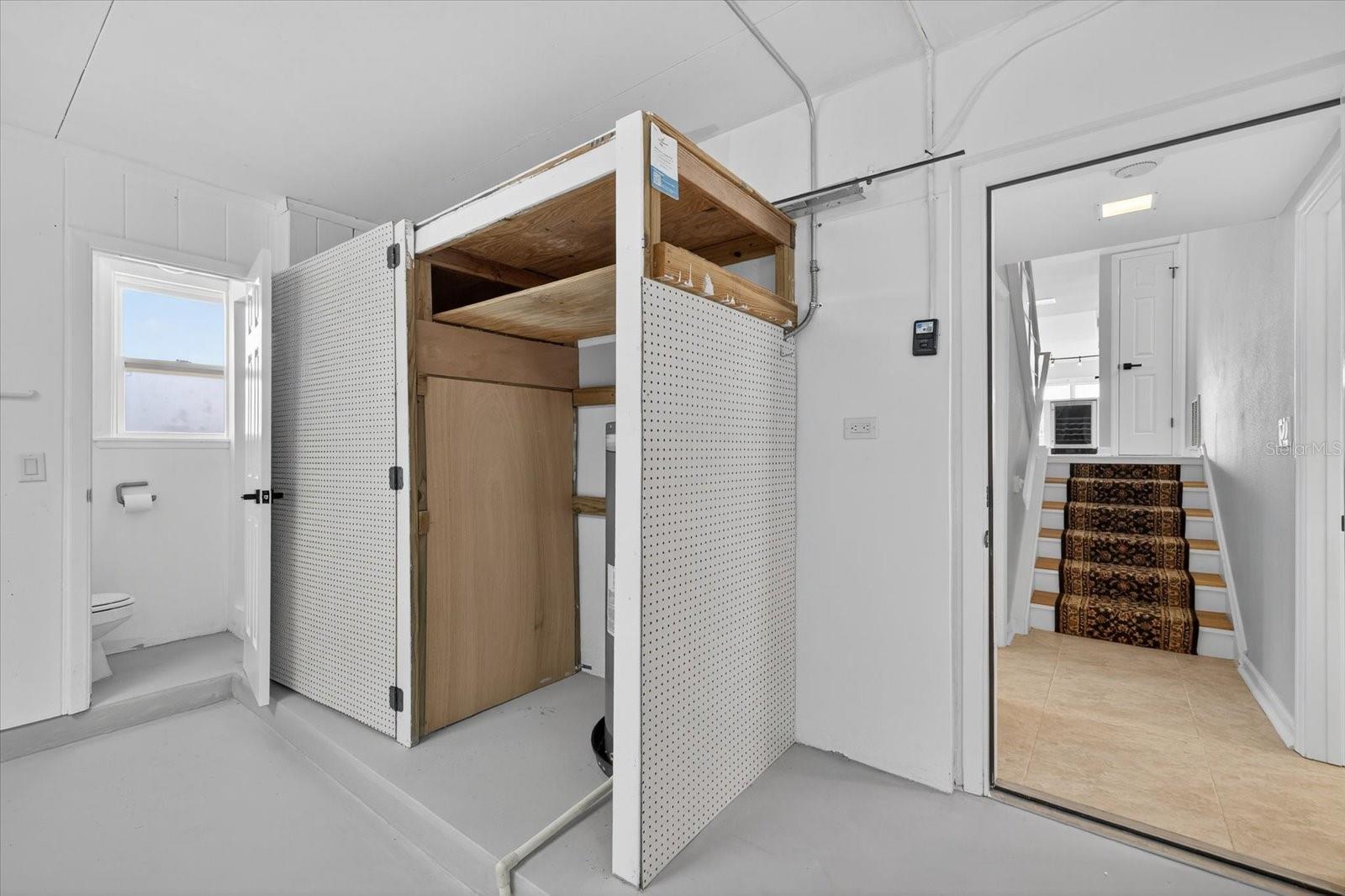 Garage view of half bath  and water heater closet