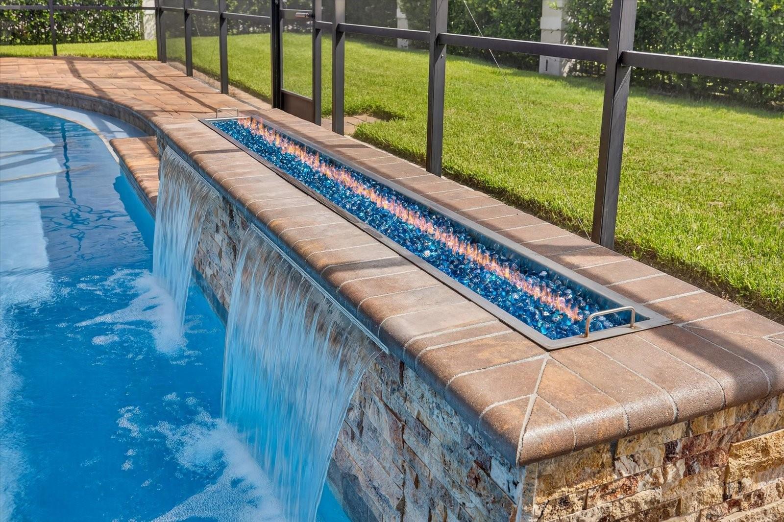 Gas fire feature with dual waterfall in saltwater pool.