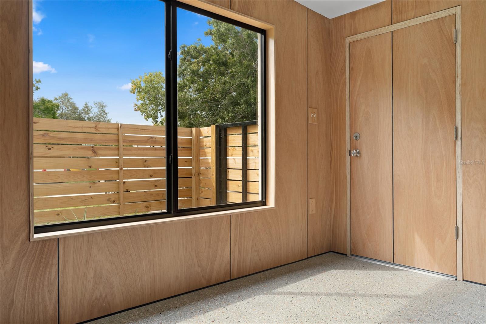 Custom solid wood door and fenced in front yard.