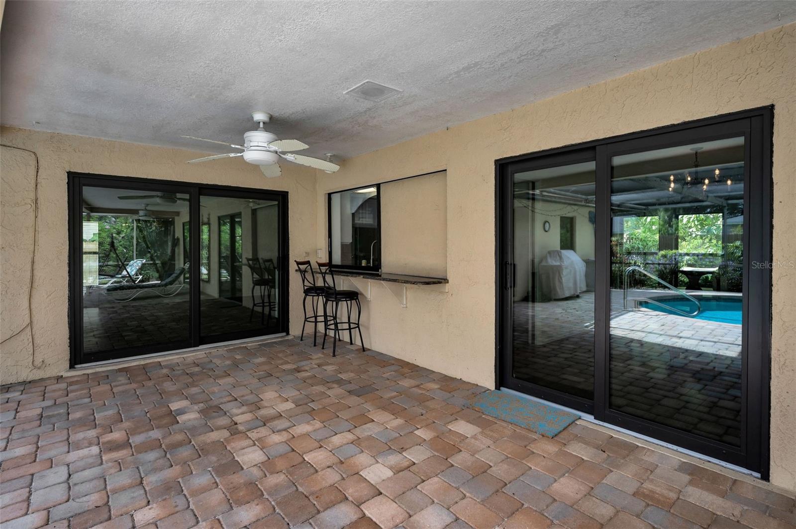 Pavered Pool Area with Sliding Doors to Family and  Dining Areas
