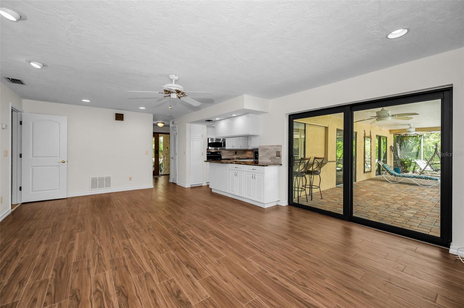 Family Room has PGT Impact Sliding Doors leading to the Pool Area