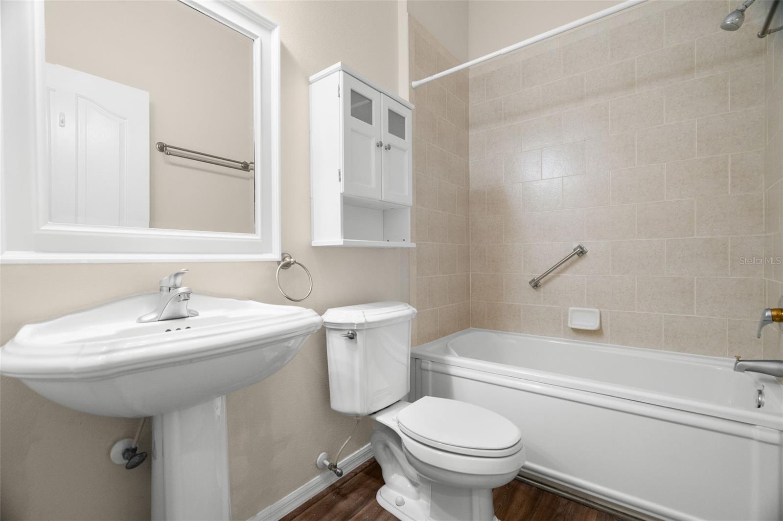 The guest bathroom has a pedestal sink and very nice jetted garden tub.