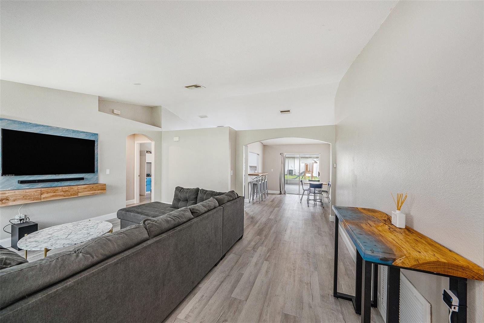 Light and bright entry with vaulted ceilings, natural light, vinyl floors, and neutral colors.