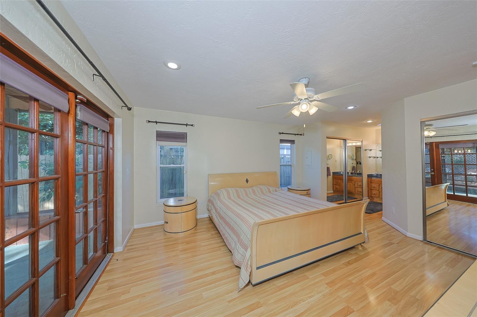Primary bedroom with 2 closets, door to the back porch, and ensuite bath with shower.