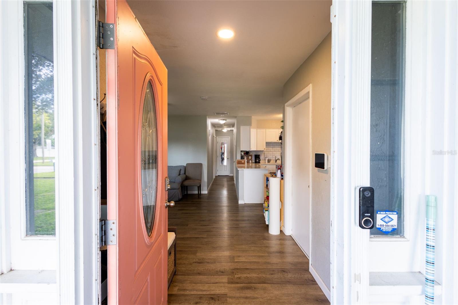 Opens up to vinyl plank flooring and an open floor plan, garage door on the right