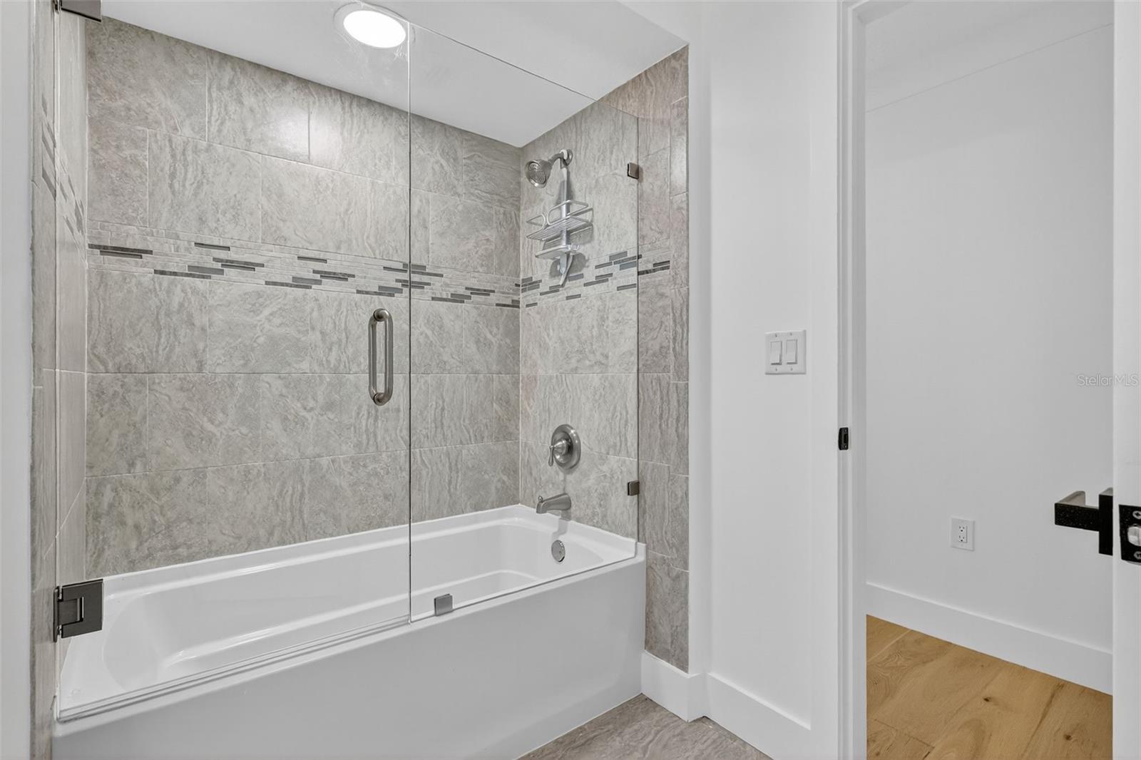 The tub/shower in the 2nd bath has glass enclsoure and tiled walls