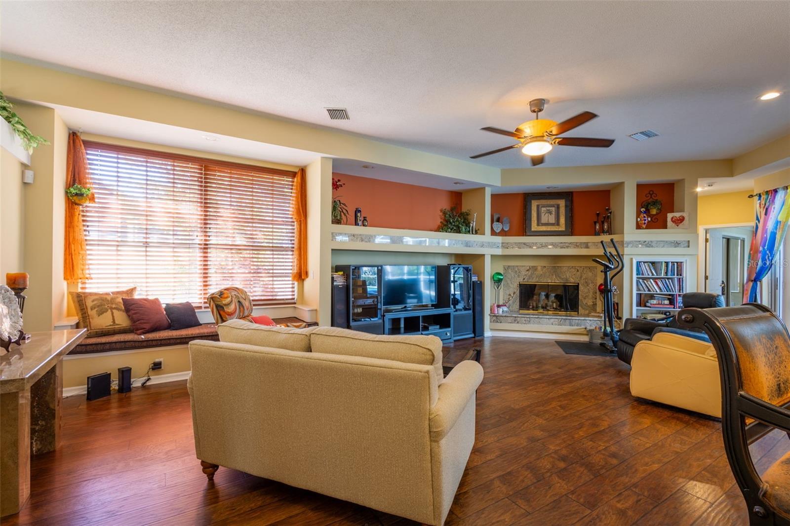 Family room, wood floors and a Fireplace. The 3rd and 4th guest rooms and 3rd full bathroom is to the right behind the book shelf.