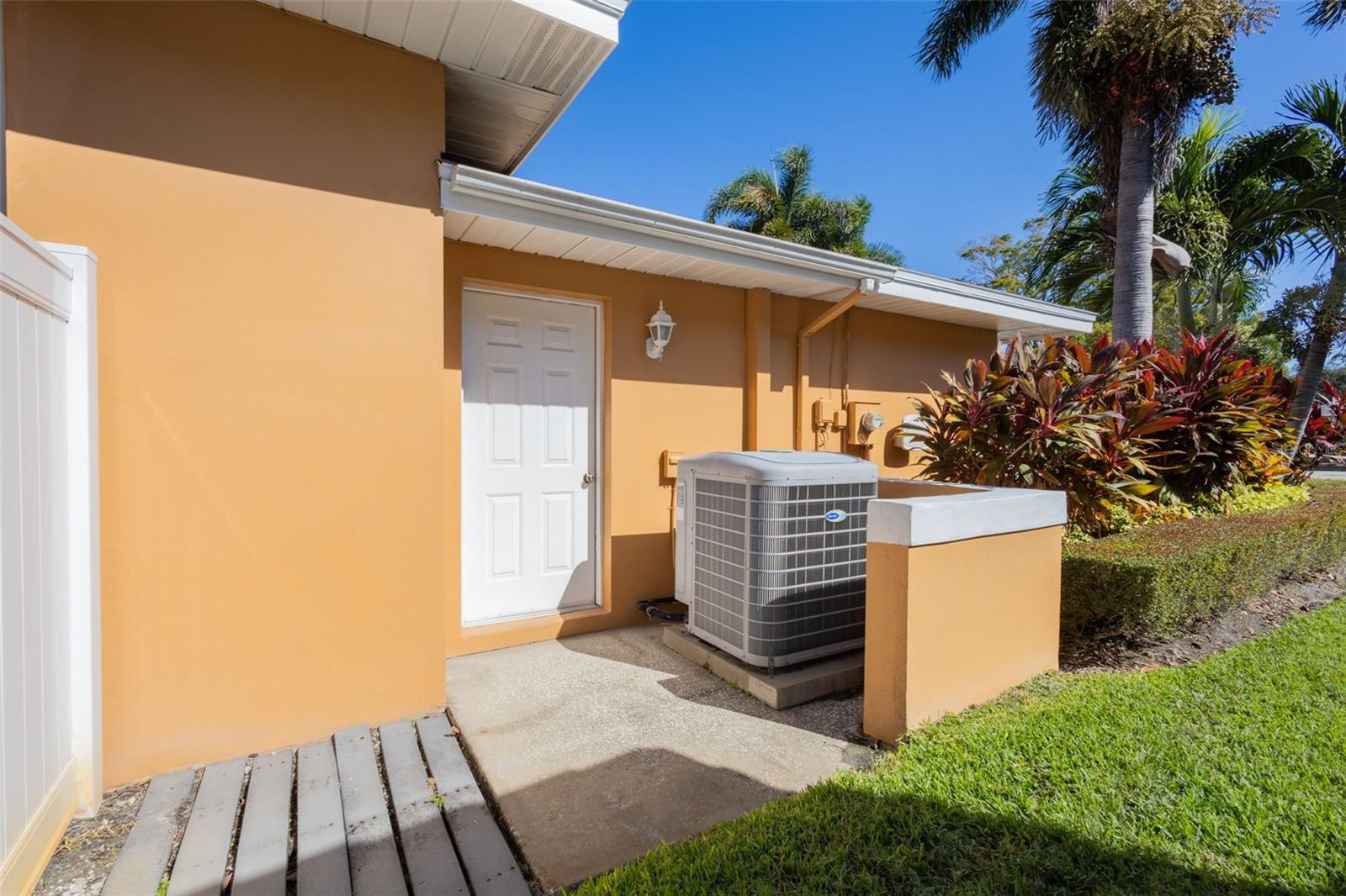 Side garage door, white PVC fencing around the yard.