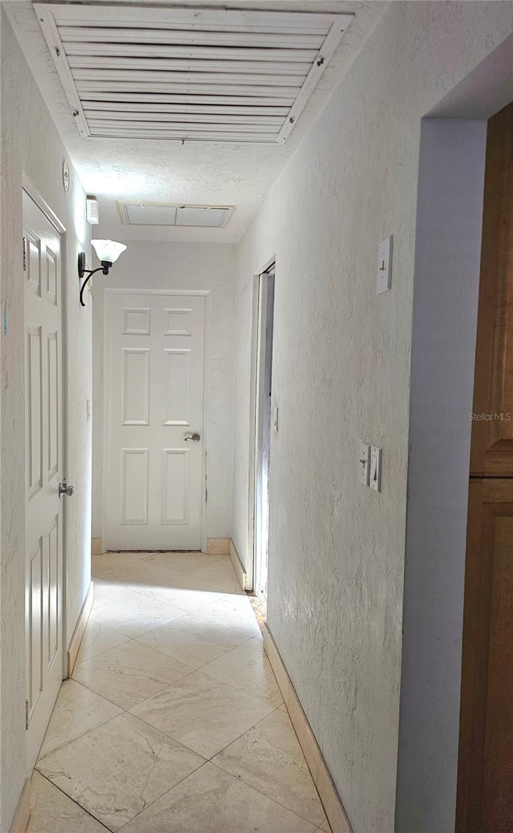 Hallway off from kitchen, leading to guest bedrooms and bath.