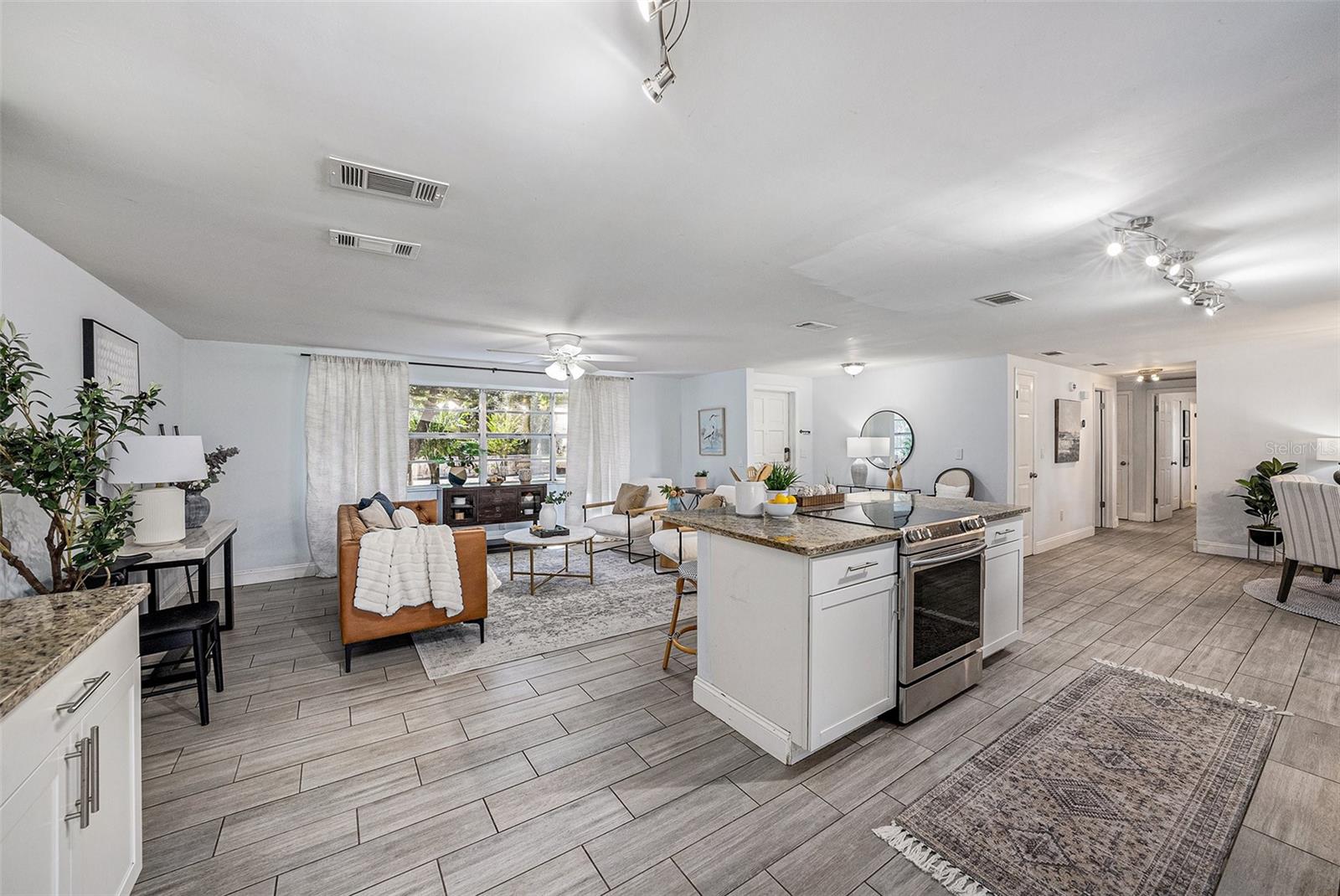 Living Room opens to kitchen, dining room and has double sliding doors that open to the pool lanai