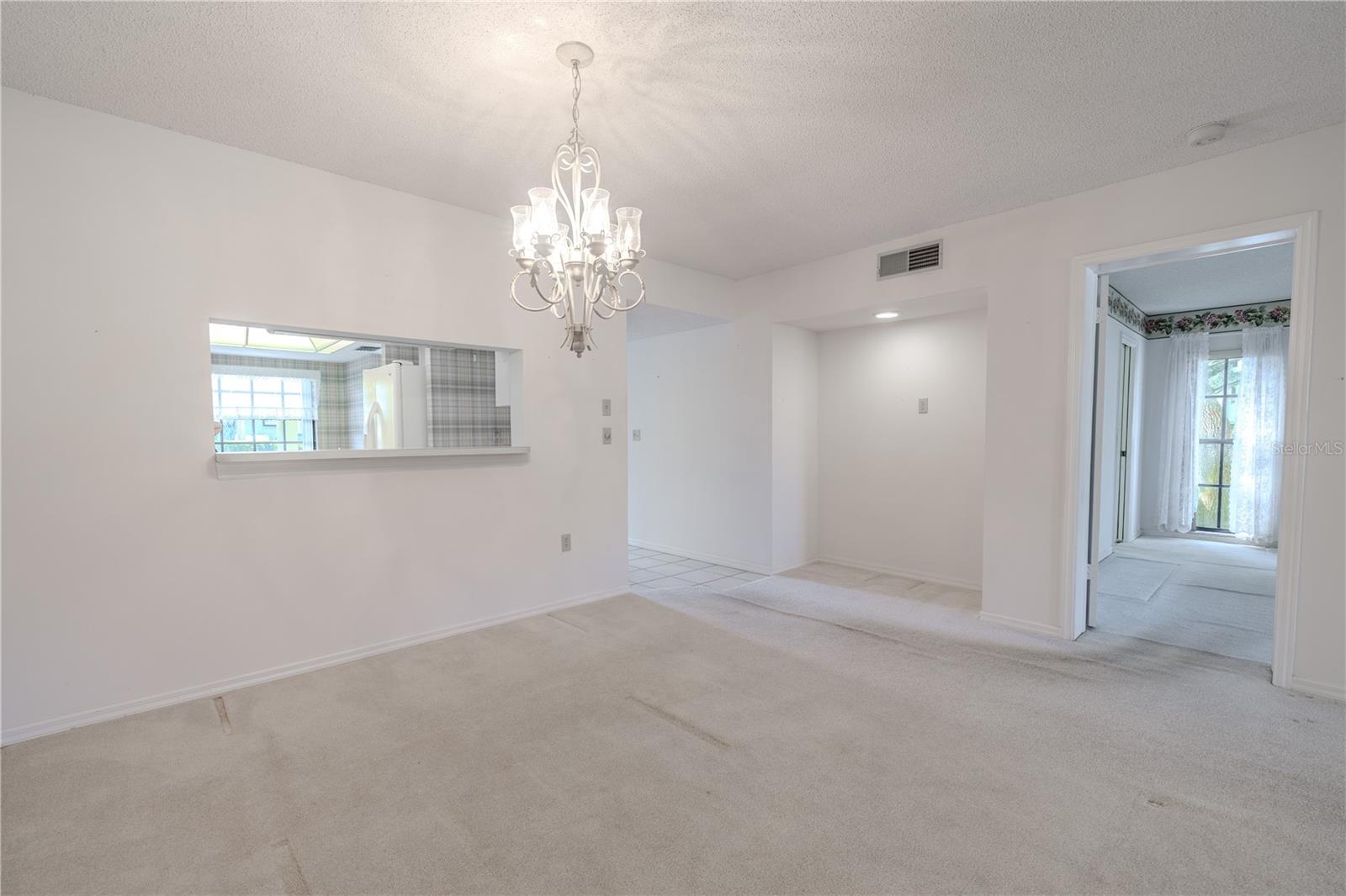 Dedicated dining space with chandelier lighting and natural light from the lanai.