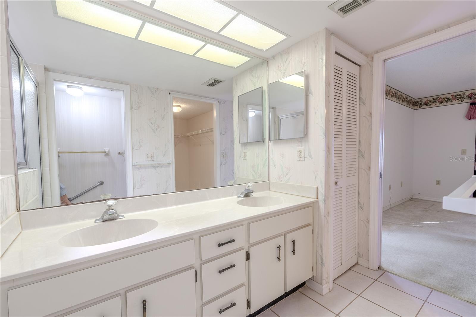 Primary bath with dual sinks, wide mirror, and plenty of counter space.