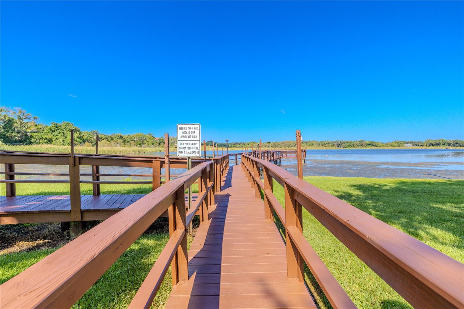 The wooden walkway draws you toward the community pier, where the lake and sky meet in a serene view.