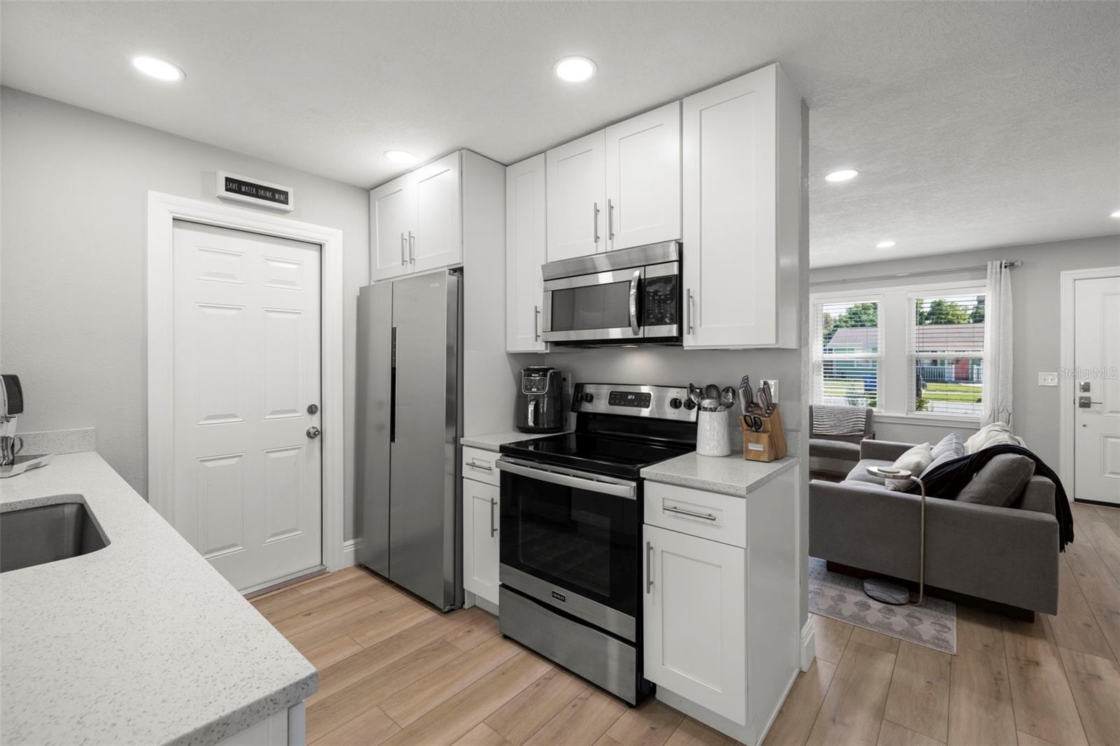 Updated kitchen with wood soft close cabinets and stainless steel appliances and quartz countertops and updated lighting and flooring