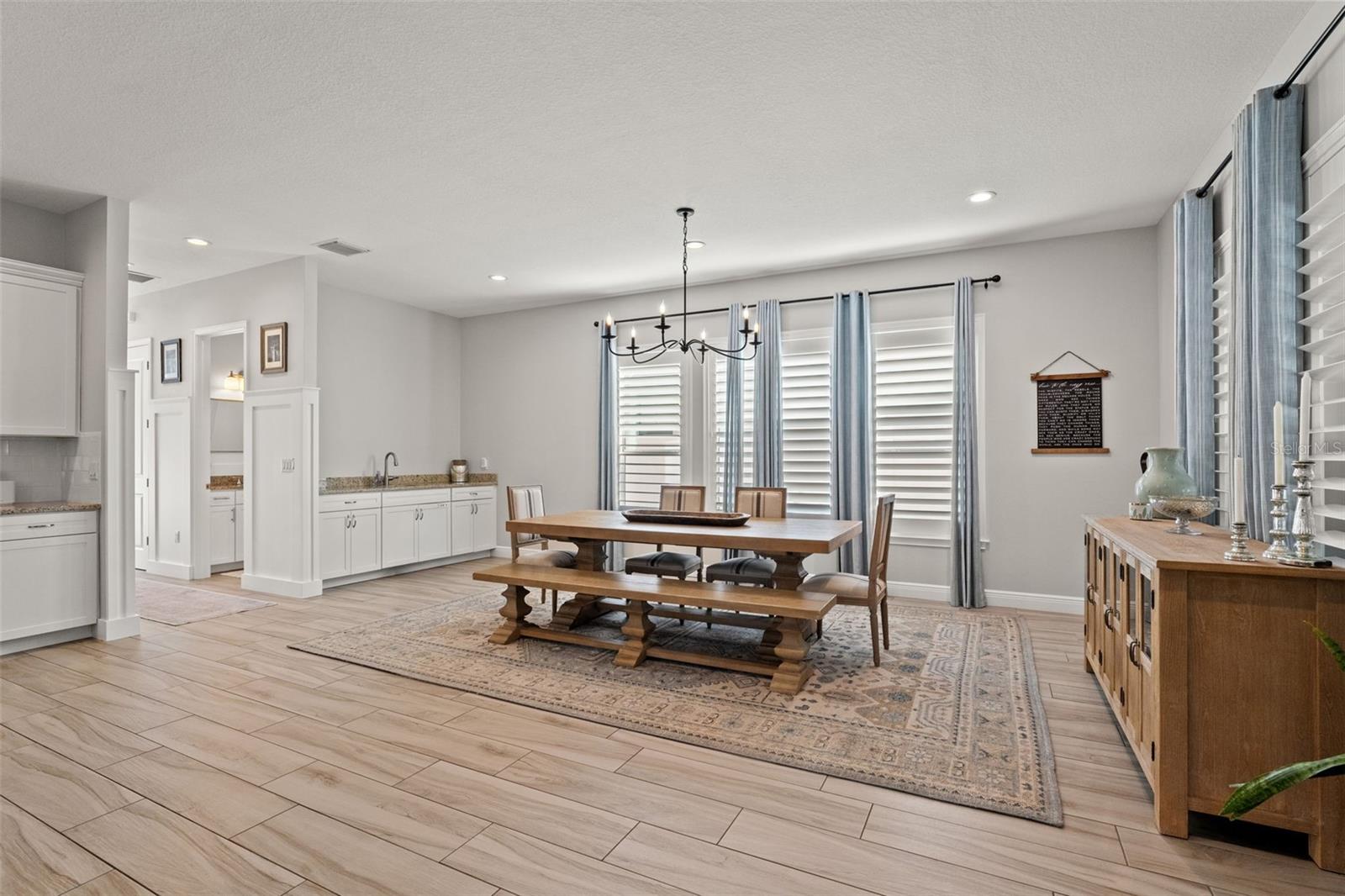 Bright and airy space with built-in cabinetry and granite counter for convenient serving and storage.
