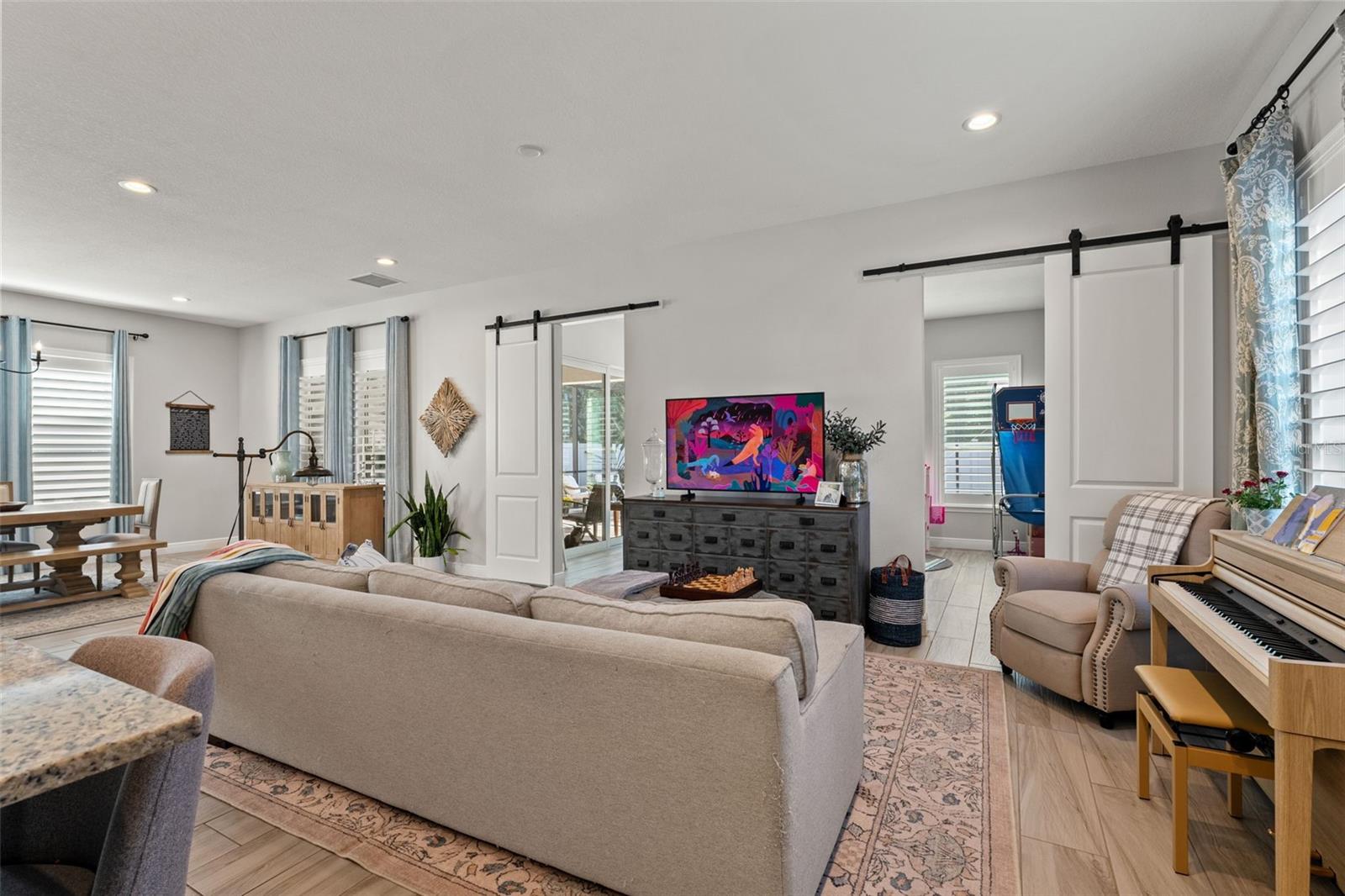 Comfortable living area featuring sliding barn doors, designer window treatments, and plenty of room for relaxation.